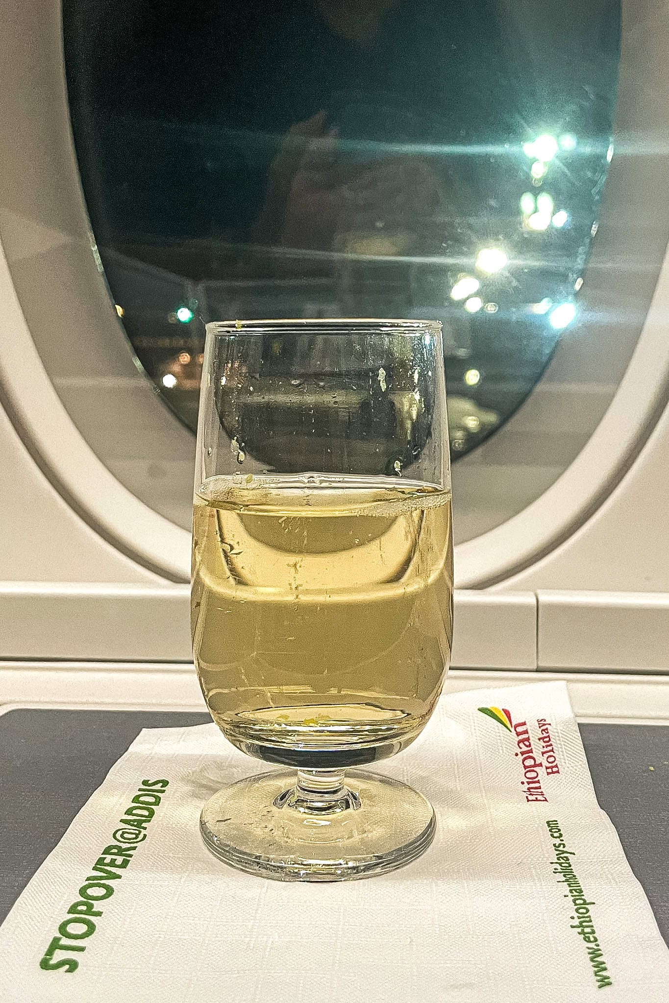 A glass of Champagne sitting on an Ethiopian airlines napkin 