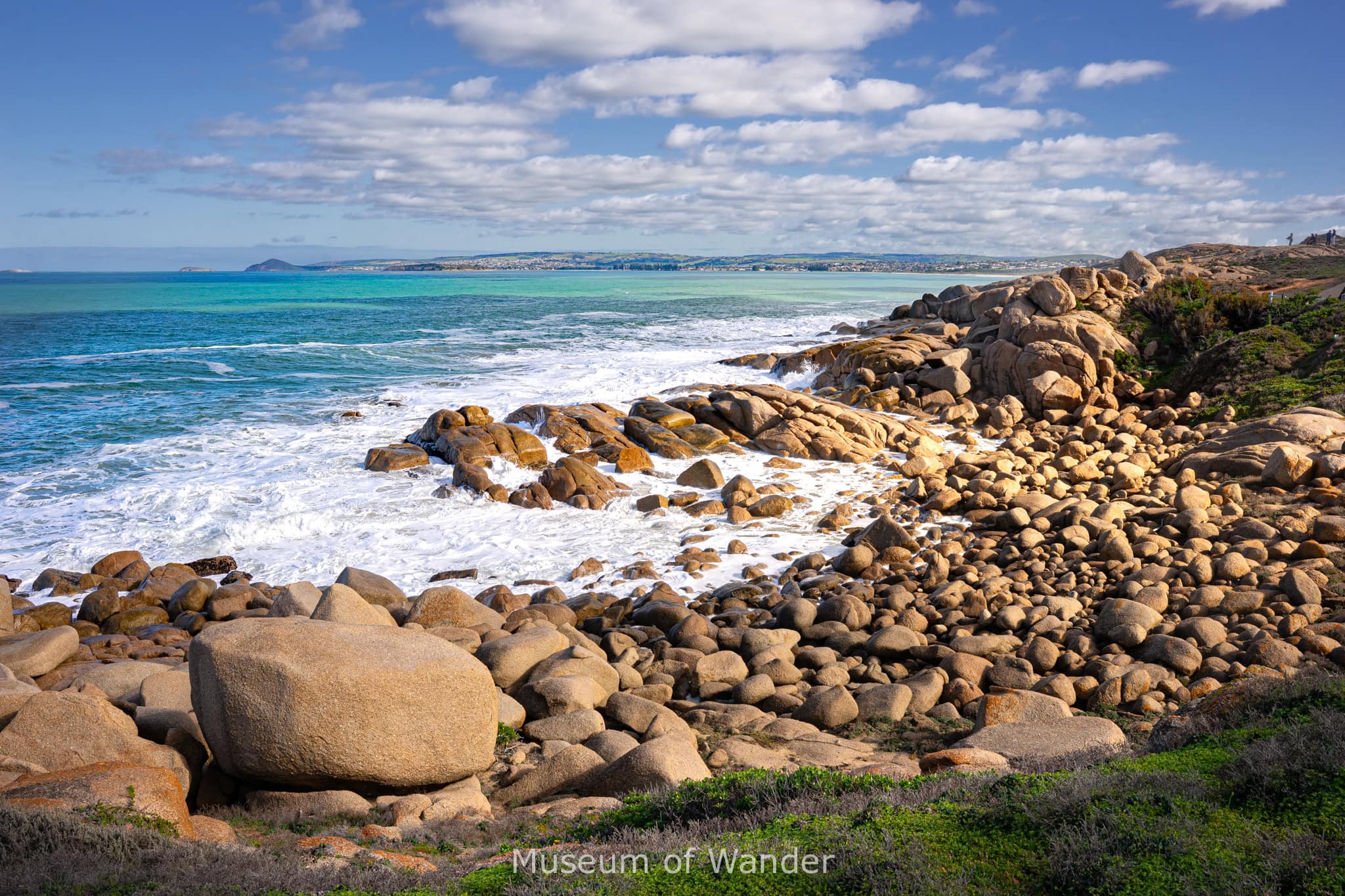 Blue ocean and white frothy waves slamming into granite boulders in Port Elliot that we saw on or day trip to Victor Harbor from Adelaide