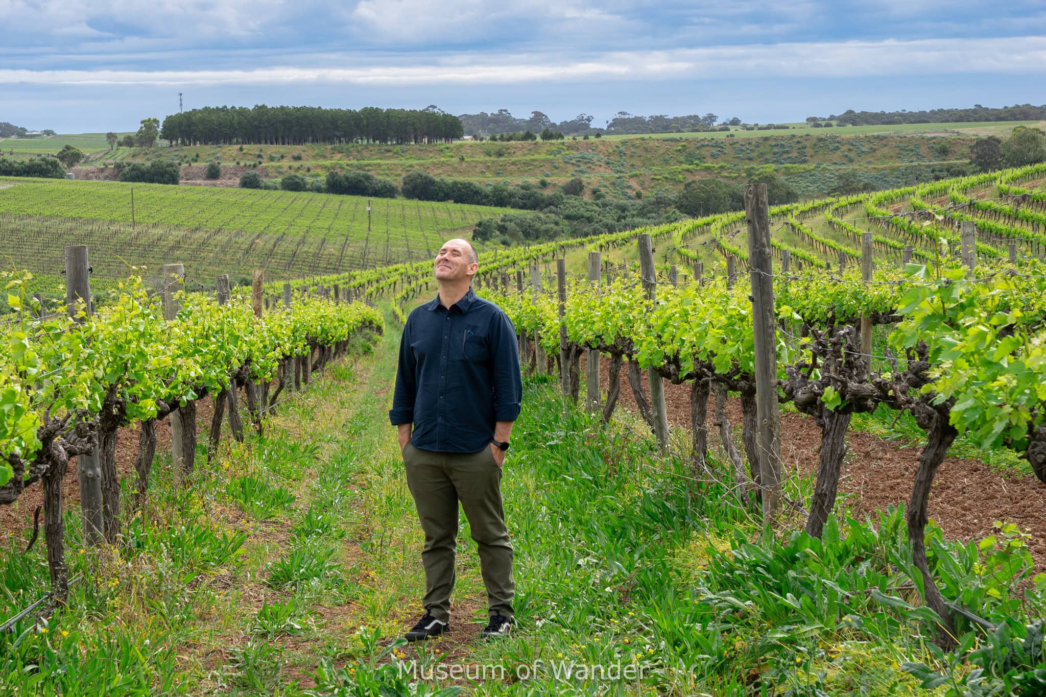 I am standing with a smug look on my face between vineyards that we visited during our McLaren Vale Day trip from Adelaide